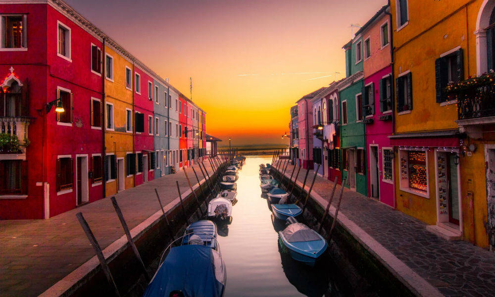 Små både der står i en havn omringet af farverige lejligheder